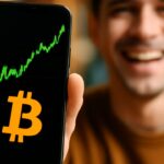 Smartphone toont een stijgende groene Bitcoin-koersgrafiek met het oranje Bitcoin-logo