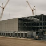 Datacenter in aanbouw in Michigan met koelunits en zware stroomaansluitingen onder een bewolkte hemel