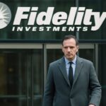 Ingang van een Fidelity-kantoorgebouw met het logo op de glazen gevel, terwijl een persoon voorbijloopt
