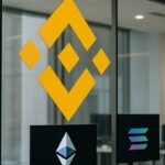 Het BNB-logo prominent op een kantoormuur met kleinere Ethereum- en Solana-logo's ernaast