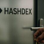 Een hand sluit een kantoordeur met het Hashdex-logo op het glas