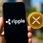 Een smartphone toont het Ripple-logo naast een los XRP-symbool, als beeld voor het verschil tussen bedrijf en munt