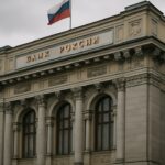 Het gebouw van de Russische centrale bank in Moskou onder een grijze lucht met de Russische vlag