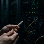Handen van een technicus bij een serverrack met netwerkkabels en waarschuwingslampjes, met het Solana-logo zichtbaar
