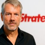 Michael Saylor van Strategy voor een banner met het bedrijfslogo tijdens een persmoment