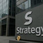 Kantoorgebouw met het logo van Strategy, met een kleine Bitcoin-munt bij de ingang