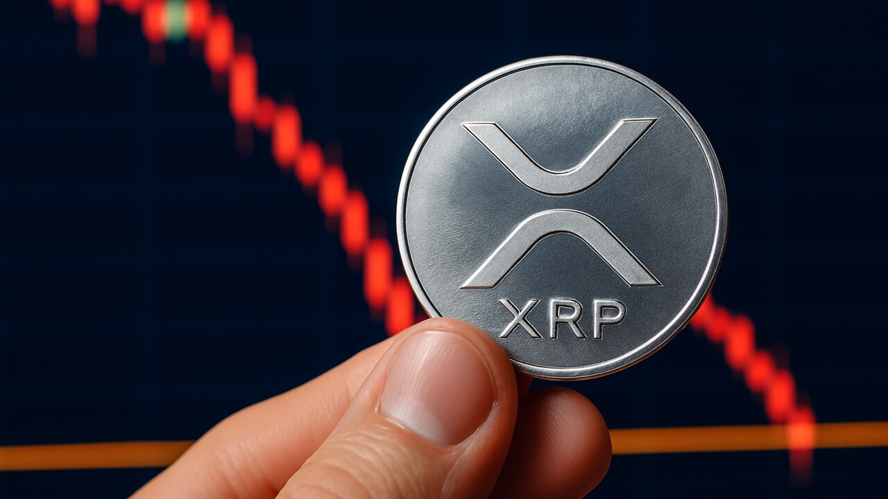 Fysieke XRP-munt voor een scherm met een dalende koersgrafiek die een steunlijn nadert
