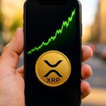 Smartphone toont een sterk stijgende groene XRP-koersgrafiek met het XRP-logo