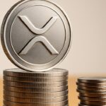 Fysieke XRP-munt op een groeiende stapel munten die een kleinere stapel overschaduwt