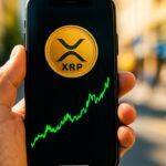 Smartphone met het XRP-logo en een groene koersgrafiek in een hand op straat