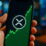 Smartphone met het Ripple XRP-logo en een stijgende groene grafiek, gehouden in een hand