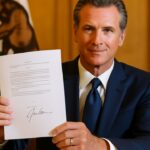 Gouverneur Gavin Newsom toont een ondertekende wet voor de vlag van Californië