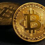 Een glanzende bitcoin-munt scherp op de voorgrond naast een doffe, nagemaakte munt, symbool voor de discussie over echte versus valse bitcoin.
