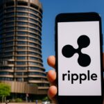 Smartphone met het Ripple-logo voor de ronde toren van de Bank for International Settlements in Bazel