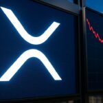 Groot XRP-logo op een beursscherm met een dalende rode koerslijn ernaast