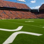XRP-logo geschilderd op het gras van een vol Amerikaans college football-stadion overdag