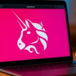 Het roze Uniswap-eenhoornlogo groot en scherp op een laptopscherm met een browser-adresbalk