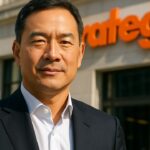 Phong Le, CEO van Strategy, voor een gevel met het oranje Strategy-logo