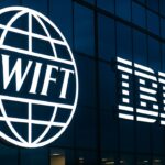 Verlichte Swift- en IBM-logo's op een moderne glazen gevel bij schemering