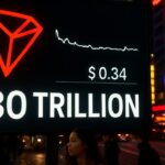 Digitaal billboard met het rode Tron-logo, een vlakke koerslijn en het getal 30 biljoen boven een drukke straat