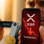 Handen houden een hardware wallet vast met een leeg saldo en een telefoon met een rode XRP-transactiemelding