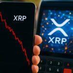 Smartphone met dalende rode XRP koersgrafiek en het XRP-logo, met op de achtergrond drukke netwerkactiviteit