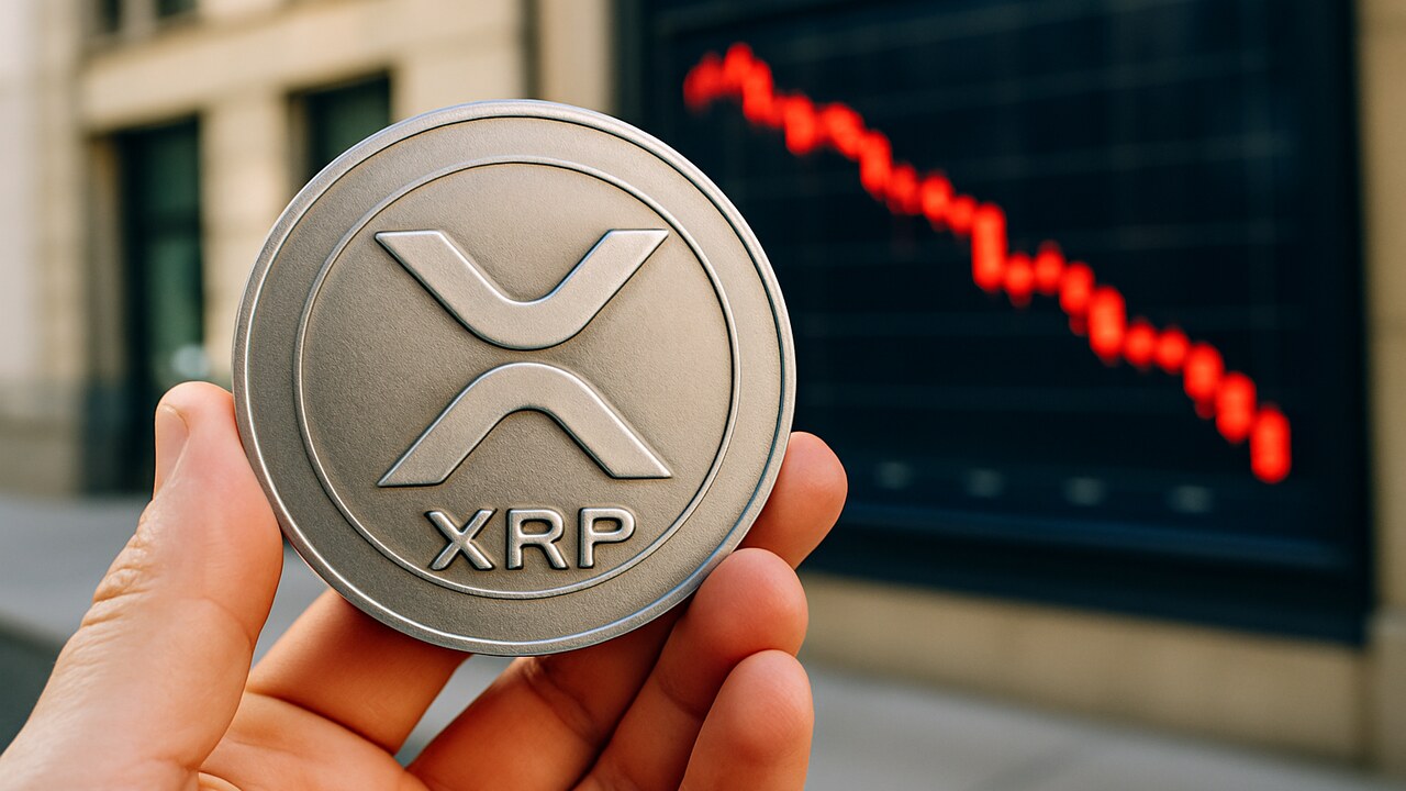Fysieke XRP-munt met logo voor een scherm met een dalende rode koersgrafiek