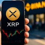 Smartphone met XRP-logo en futures-grafiek voor een Binance-banner op straat