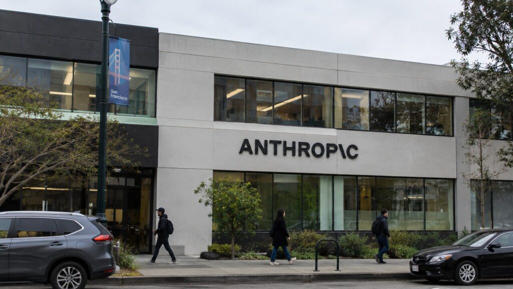 Gevel van een kantoorgebouw in San Francisco met het Anthropic-logo, gezien vanaf straatniveau met voorbijgangers