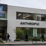 Gevel van een kantoorgebouw in San Francisco met het Anthropic-logo, gezien vanaf straatniveau met voorbijgangers