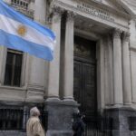 Gevel van de Argentijnse centrale bank in Buenos Aires met een wapperende Argentijnse vlag op de voorgrond