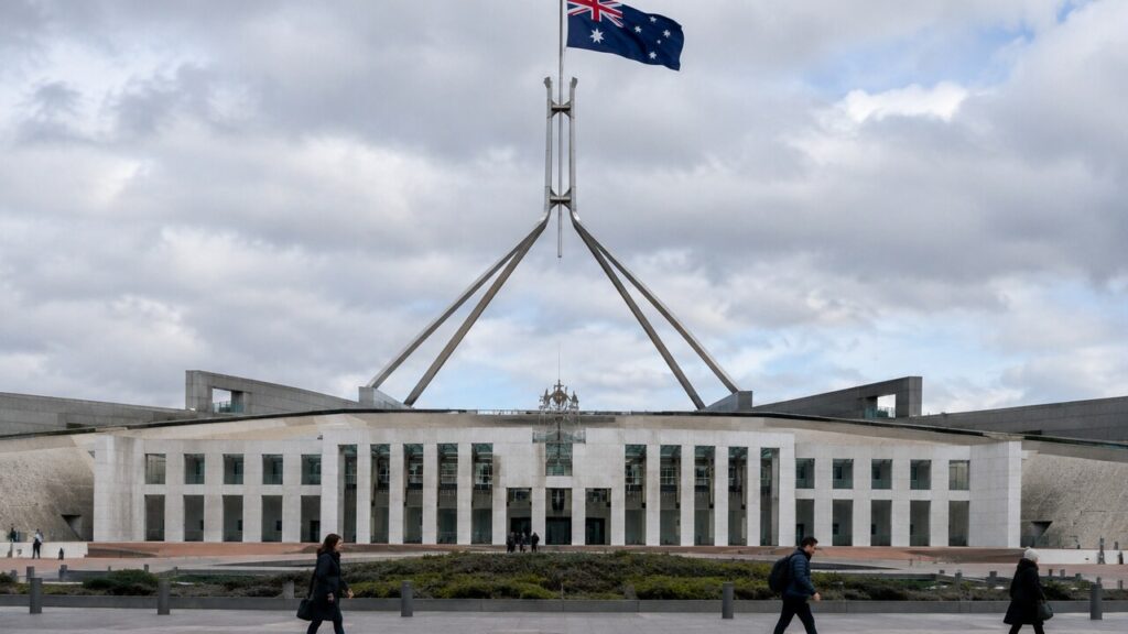 De Australische vlag wappert boven het parlementsgebouw in Canberra op een bewolkte ochtend