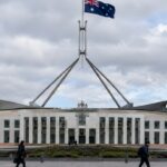 De Australische vlag wappert boven het parlementsgebouw in Canberra op een bewolkte ochtend