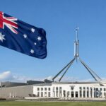 Australische vlag wappert voor het parlementsgebouw in Canberra op een zonnige dag