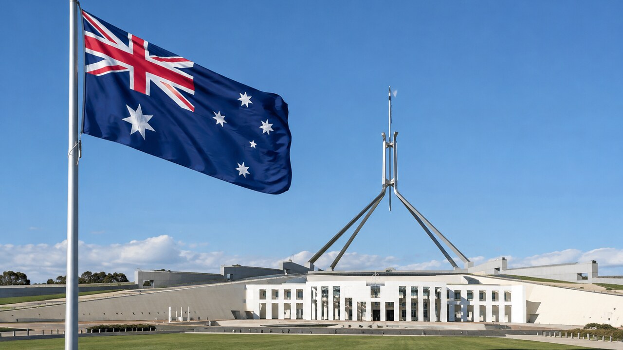 Australische vlag wappert voor het parlementsgebouw in Canberra op een zonnige dag