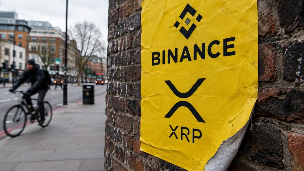Geel reclameaffiche met het Binance-logo en het XRP-logo op een bakstenen muur, met een loslatende hoek