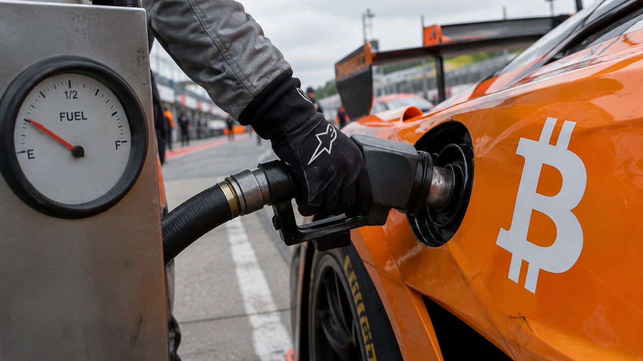 Monteur tankt een oranje raceauto met een groot Bitcoin-logo bij een pitstop, terwijl de brandstofmeter nog maar een kwart vol staat