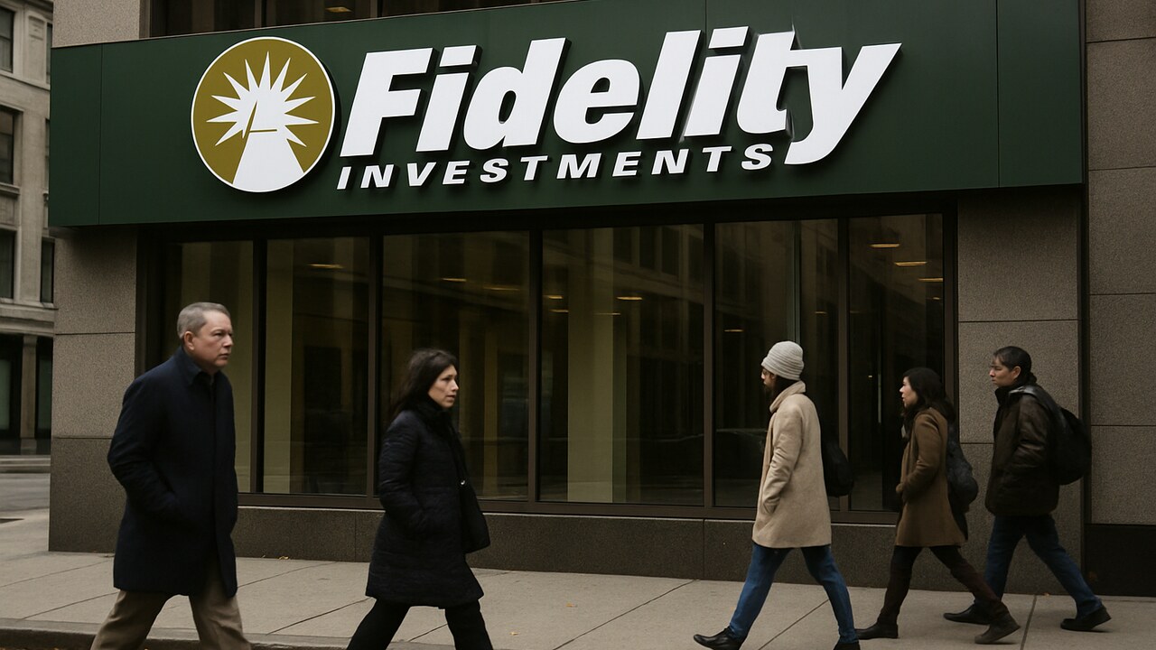 Gevel van een Fidelity-gebouw met groot logo, voetgangers lopen voorbij op een bewolkte herfstmiddag