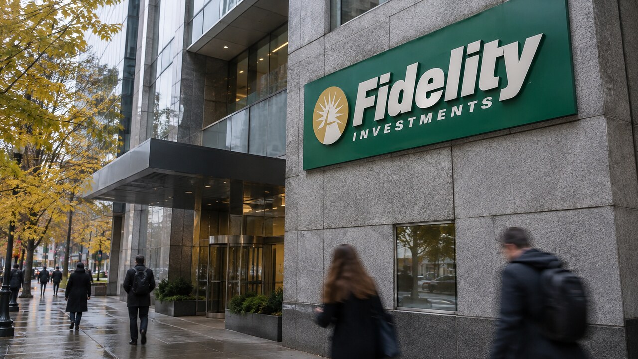 Gevel van het hoofdkantoor van Fidelity Investments in Boston met het groene Fidelity-logo, voorbijgangers op een bewolkte herfstdag