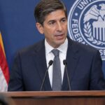 Fed-voorzitter Kevin Warsh spreekt achter een katheder met het zegel van de Federal Reserve tijdens een persconferentie