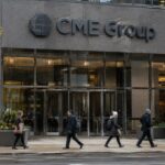 Gevel van het CME Group-hoofdkantoor in Chicago met groot logo en voorbijgangers op een bewolkte middag