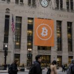 Het Chicago Board of Trade-gebouw in Chicago met een oranje Bitcoin-banier op de gevel en voorbijgangers op straat