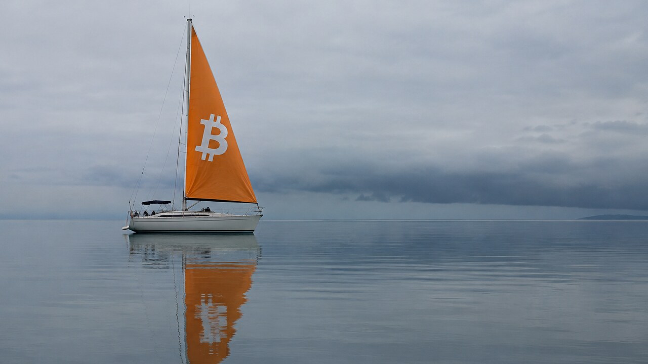Zeilboot met oranje zeil en Bitcoin-logo ligt stil op een spiegelgladde zee, met donkere wolken aan de horizon