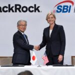 Ondertekeningsceremonie op een podium in Tokio met de logo's van BlackRock en SBI Holdings op de achtergrond en twee bestuurders die elkaar de hand schudden