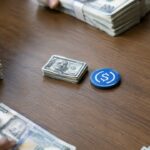 Grote stapel dollarbiljetten wordt verdeeld en weggeschoven, met een klein stapeltje en een USDC-munt in het midden