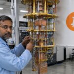 Quantumcomputer in een laboratorium met een groot oranje Bitcoin-logo op de koelbehuizing en een technicus die kabels afstelt