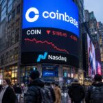 Groot scherm op de Nasdaq-gevel in New York toont het Coinbase-logo met een dalende rode koerslijn boven voorbijgangers