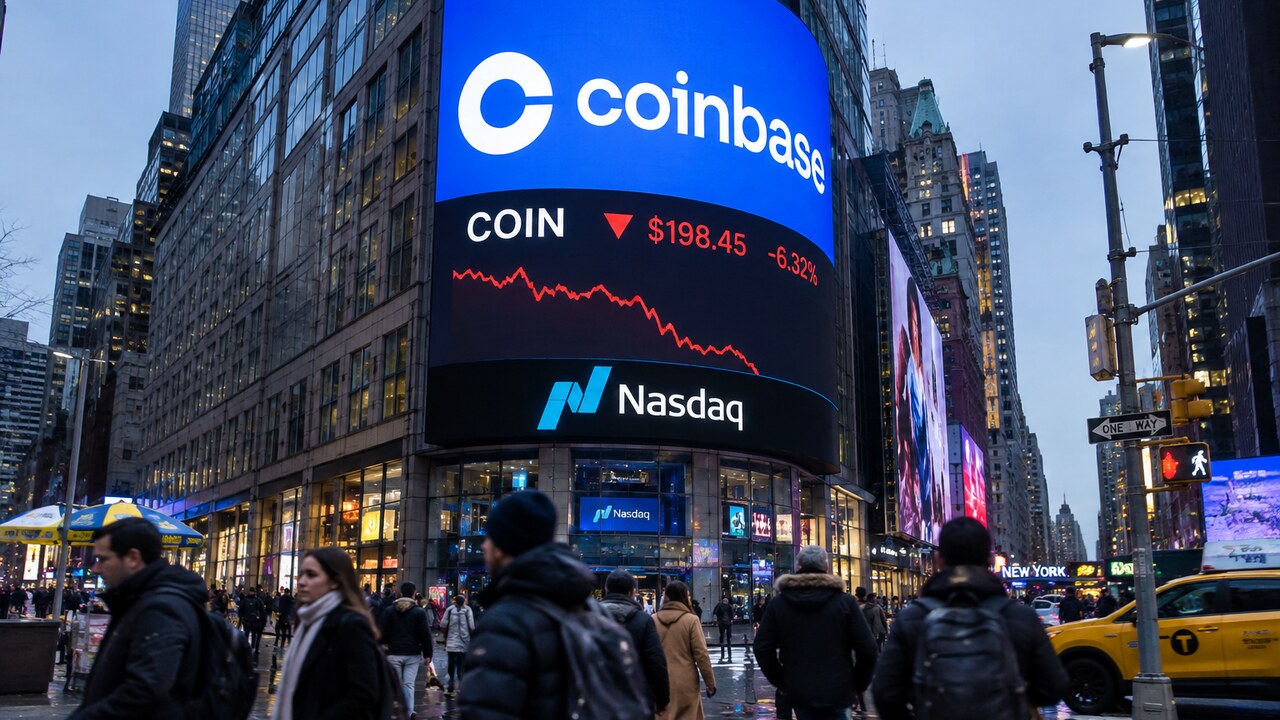 Groot scherm op de Nasdaq-gevel in New York toont het Coinbase-logo met een dalende rode koerslijn boven voorbijgangers