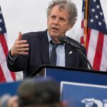 Sherrod Brown spreekt op een campagnebijeenkomst in Ohio voor Amerikaanse vlaggen en aanhangers met borden