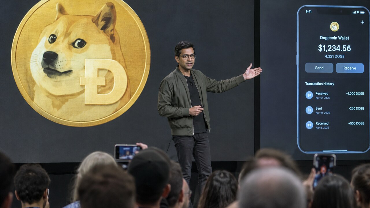 Presentator op een podium van een cryptoconferentie voor een groot scherm met het Dogecoin-logo, terwijl het publiek toekijkt
